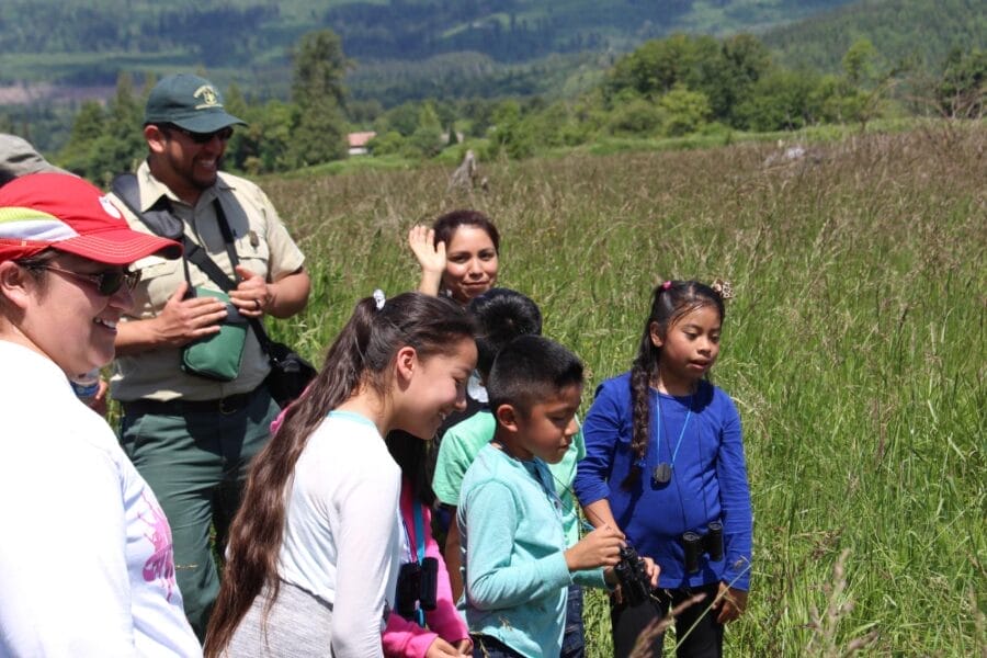 Kulshan Creek Neighborhood youth group standing in the field at Utopia Conservation Area. 