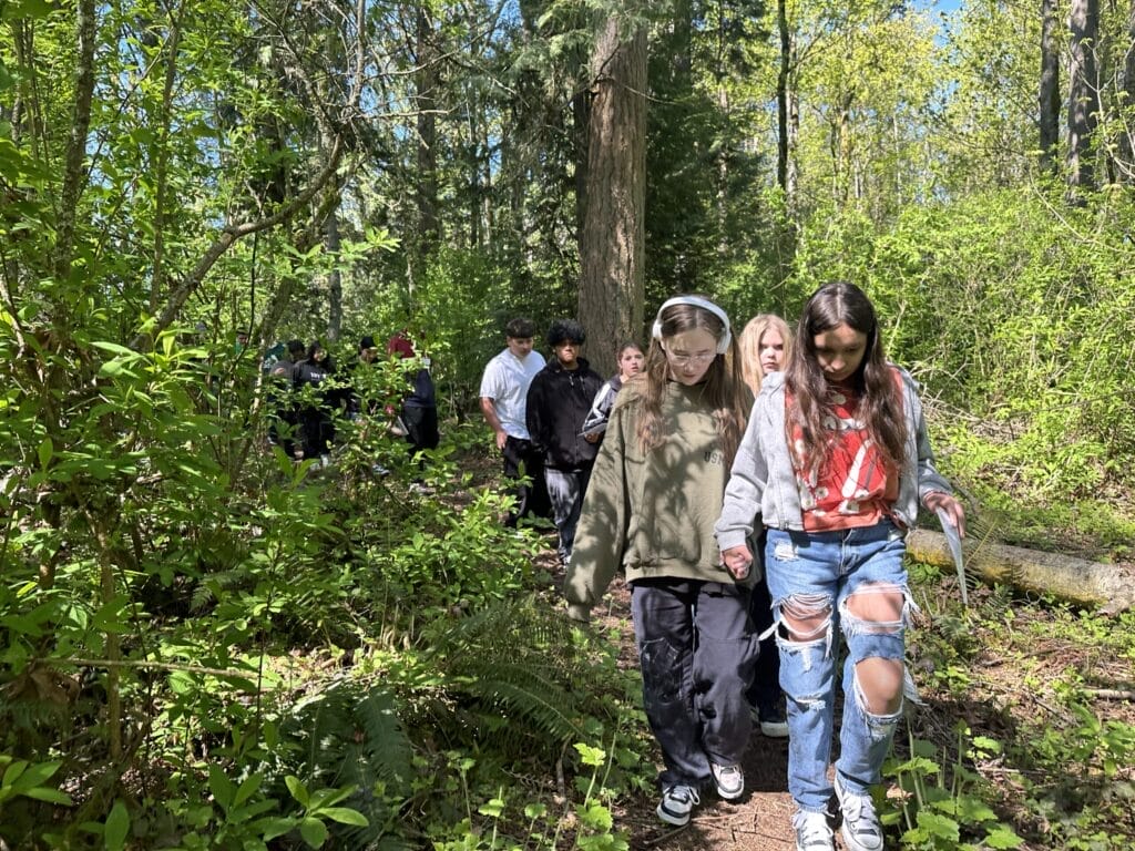 Children walk down a forest trail.